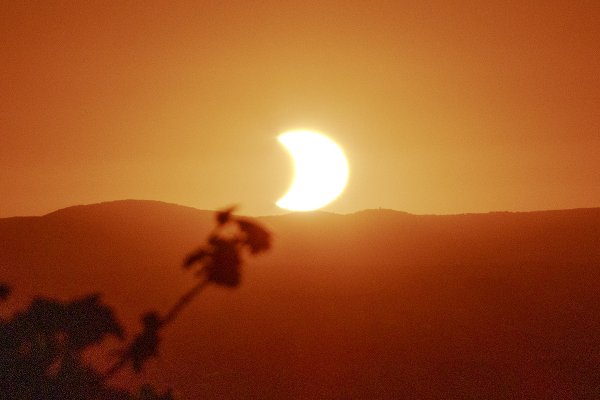 Verfinsterte Sonne tief über dem Horizont
